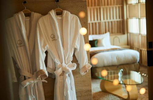 a robe is hanging in a room with a bed at THE HIRAMATSU HOTELS & RESORTS KASHIKOJIMA in Shima