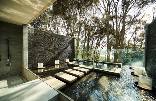 a bathroom with a pond with a bench and aitating at THE HIRAMATSU HOTELS & RESORTS KASHIKOJIMA in Shima