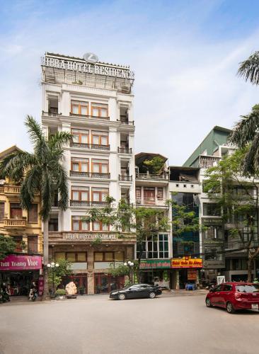 a large white building with cars parked in front of it at Libra Hotel Residence by Luxe Paradise in Hanoi
