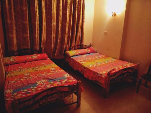 two beds in a small room with curtains at شمس أسوان شقة شعبية رخيصة أمان in Aswan