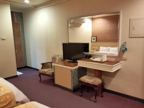 a hotel room with a desk and a mirror at 夏威夷酒店Melody Hawaii Hotel in Taitung City