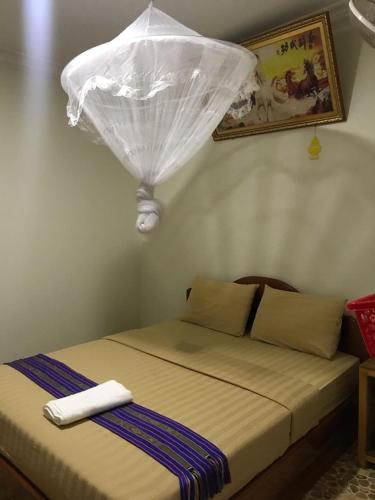 a bed in a room with a white curtain on it at Manel Guesthouse and Restaurant in Sen Monorom