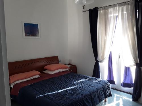 a bedroom with a bed and a window at MARGIE'S HOUSE in Procida