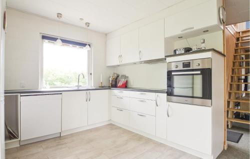 a white kitchen with white cabinets and a window at Fjordens Perle in Farsø