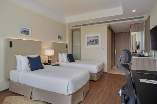 a hotel room with two beds and a kitchen at O by Tamara, Trivandrum in Trivandrum