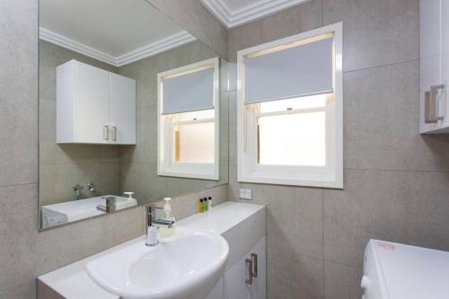uma casa de banho com um lavatório e um espelho em M5 West Perth Studio Apartment near Kings Park em Perth