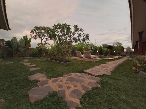 a garden with rocks and a bench on the grass at Ayuna Family Ubud in Ubud