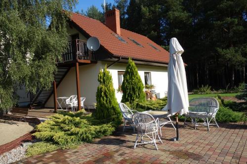 un patio con una mesa y una sombrilla blanca en Bednarzówka, en Nowy Tomyśl