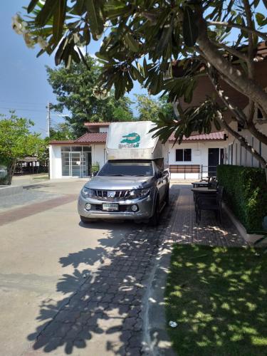 a car parked in front of a house with a truck at The Chill House in Ban Wang Khanai