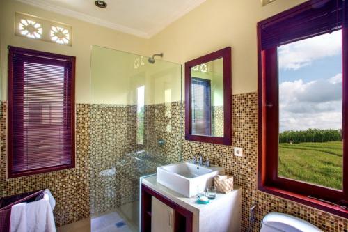 a bathroom with a sink and a mirror at Tiga Samudra Villa in Canggu