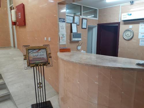 a lobby with a bar with a tv in it at فندق الجوهرة in Al Buraymī