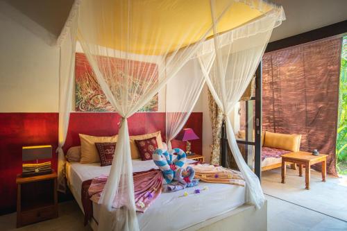 ein Schlafzimmer mit einem Himmelbett in der Unterkunft Minabali Bunga'lo in Tulamben