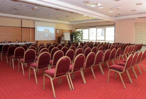 a room with a bunch of chairs in front of a screen at Best Western Plus La Fayette Hotel et SPA in Épinal