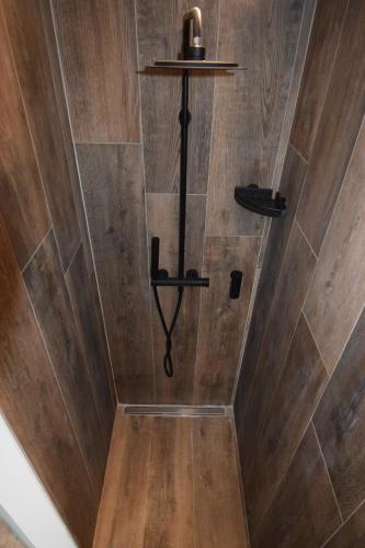 a shower with wood paneling and a wooden floor at Le Bouquet d'Arbres in Villers-la-Ville