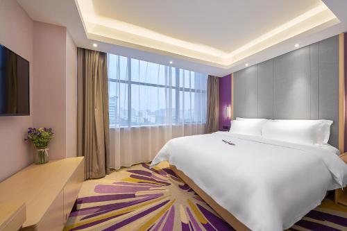 a bedroom with a large bed and a large window at Echarm International Hotel Guangzhou Baiyun International Airport Huadu Plaza Branch - Free Deliver Service to Guangzhou Baiyun International Airport & Free Deliver Service to Canton Fair Complex During Canton Fair Period in Huadu