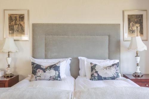 a bedroom with a bed with two pillows and two lamps at 4 Piet Retief in Stellenbosch