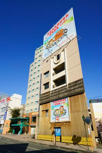 a tall building with a sign on the side of it at Hotel Seawave Beppu in Beppu