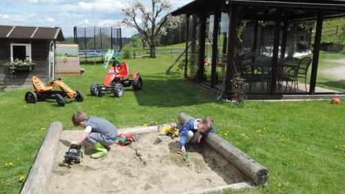 two children playing in a sandbox with toys in a sandbox at Nagerhof in Gnesau