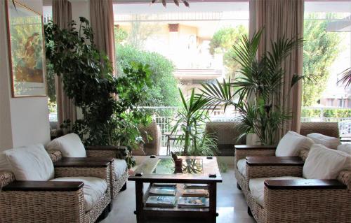 a living room with couches and a table and plants at Hotel Villa Fiorita in Milano Marittima