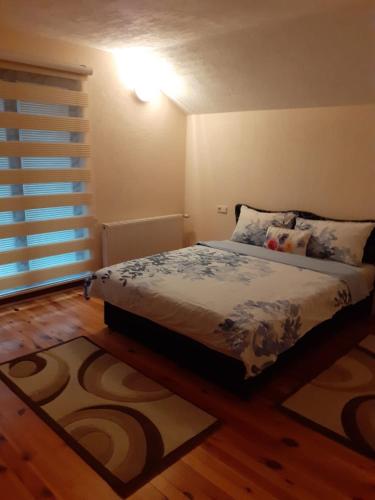 a bedroom with a bed and a wooden floor at Sweet Holiday Home in Hadžići