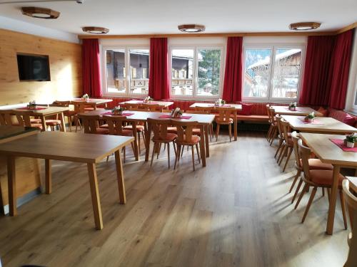 uma sala de jantar com mesas, cadeiras e janelas em Wurlerhof em Kals am Grossglockner