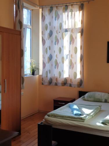 a bedroom with a bed and a window with a curtain at Elegance on a Budget - Rooms for Rent in Sofia Center in Sofia