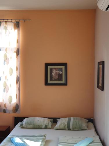 a bedroom with orange walls and a bed and a window at Elegance on a Budget - Rooms for Rent in Sofia Center in Sofia