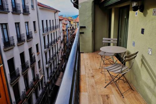 a balcony with a table and chairs in a building at Atico Estafeta in Pamplona