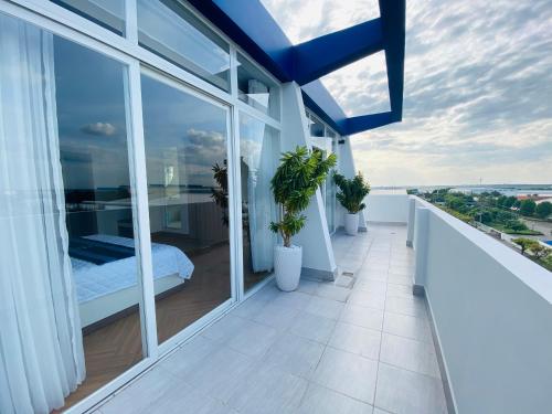 a balcony with a bed and some windows at Hung Phuoc Hotel in Bến Cát