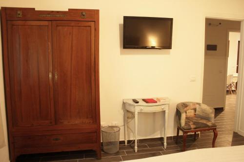 Habitación con armario de madera y silla en La Casetta di Alvaro, en Domegliara