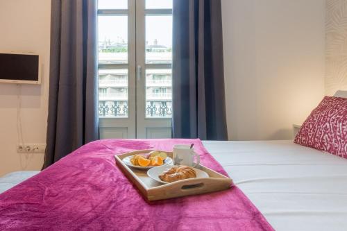 a tray of food on a bed with a window at Sibs Bcn- Balmes- Romantic CityCentre Beautiful in Barcelona