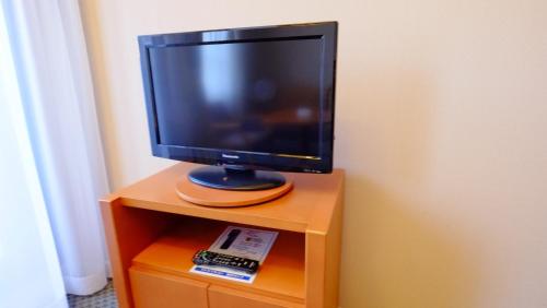 a television sitting on top of a wooden cabinet at Hotel Harvest Skijam Katsuyama in Katsuyama
