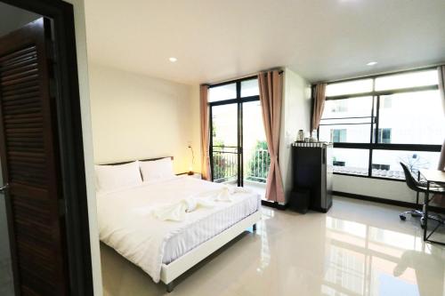 a bedroom with a bed and a large window at Baanrao Bangson in Bangkok