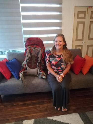 a woman sitting on a couch with a pile of backpacks at Eden Studio Apartments - 1 in Colombo