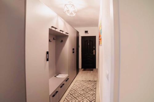un corridoio con pareti bianche e un corridoio bianco con una porta nera di Relax Apartment 1 a Sighişoara
