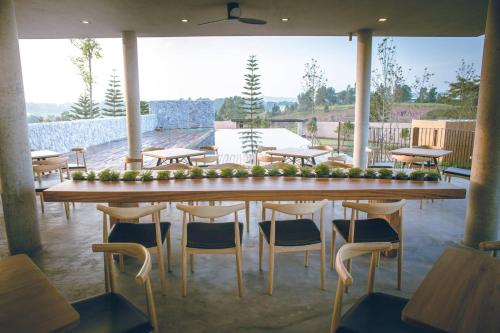 a large wooden table with chairs and a large window at De Capoc Resort in Khao Kho