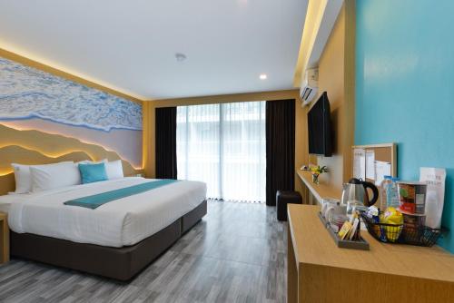 Pokój hotelowy z łóżkiem i biurkiem w obiekcie T2 Ao Nang Krabi w Aonang Beach