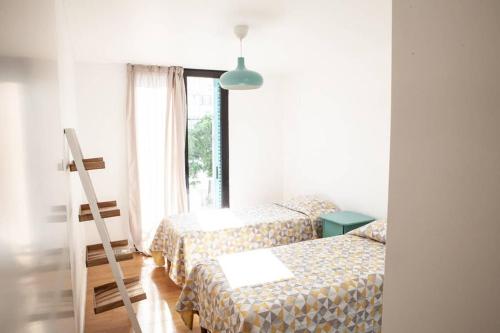 una habitación de hotel con 2 camas y una escalera en Casa Azul en Cabanas de Tavira