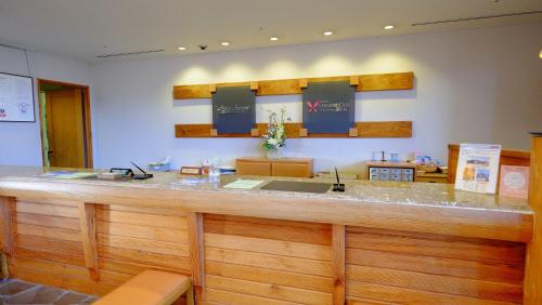 a kitchen with a large wooden counter with a sink at Hotel Harvest Skijam Katsuyama in Katsuyama