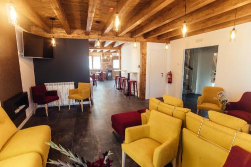 a waiting room with yellow chairs and a table at HOTEL RURAL PINARES DE SORIA (Alquiler íntegro) in Molinos de Duero