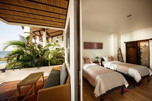 a hotel room with two beds and a balcony at Emoha Dive Resort in Oslob