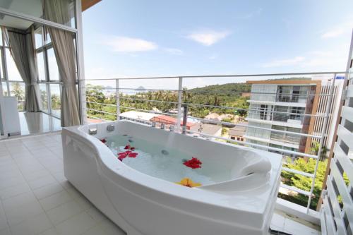 Una bañera en una habitación con una ventana grande. en At Sea Condotel, en Klong Muang Beach
