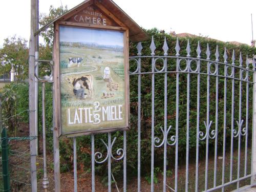 a sign on a gate in front of a fence at B&B Lattemiele in Fontanellato