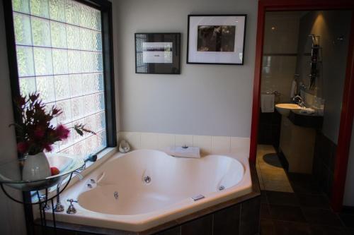 a large bath tub in a bathroom with a window at A Heavenly Escape in Halls Gap