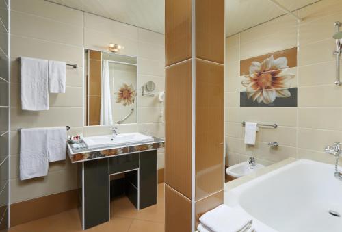 y baño con lavabo, aseo y bañera. en Bega Hotel Moscow, en Moscú