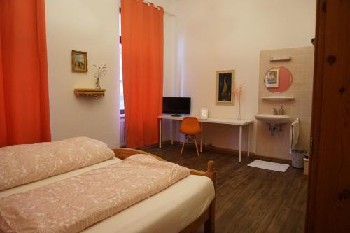 a bedroom with a bed and a desk with a computer at Pension Stadtmitte Garni in Karlsruhe