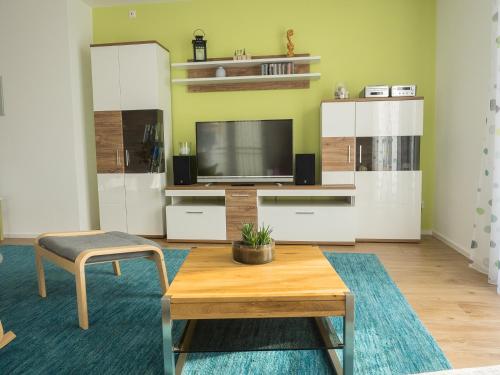 ein Wohnzimmer mit einem TV und einem Couchtisch in der Unterkunft 16Lilien Apartmentwohnung in Waiblingen