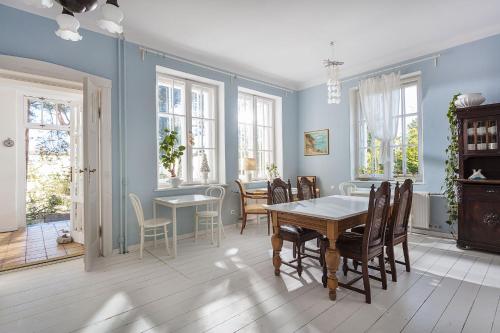 a dining room with blue walls and a table and chairs at Willa Ludwinia in Gdynia