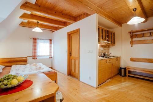 a kitchen with a table with a bowl of fruit on it at Jánošíkova Valaška Hills Apartments in Terchová