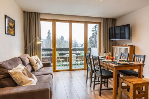 a living room with a couch and a table with chairs at Apartment Periades in Chamonix-Mont-Blanc